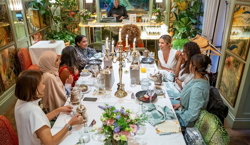 Women talking together in a soft-lit TakeOFF Collective lounge